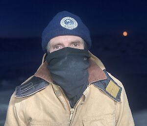 A man wearing a beanie, two face buffs and a thick jacket.