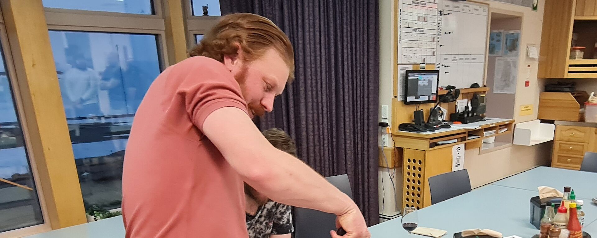 A man is about to cut into a large, multi coloured, birthday cake. The number 40 is on the top of the cake.