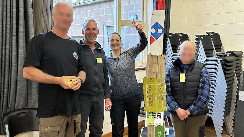 Four people inside with a tower of boxes in the foreground