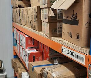 Shelves in a large freezer containing boxes of frozen goods including butter and mixed vegetables