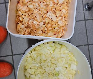 Two bowls of different coloured home-made kimchi - one pink and the other light green