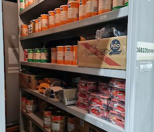 Warm store room containing shelves loaded with many varieties of herbs and packaged and canned foodstuffs