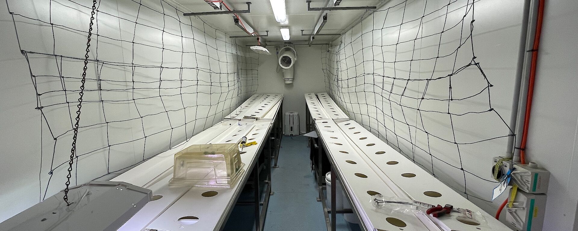Hydroponics trays sit on steel frames ready for new plants.
