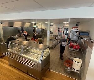 A group of people scrubbing various parts of the station's commercial kitchen.