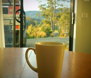 Coffee mug on a table overlooking a summer morning