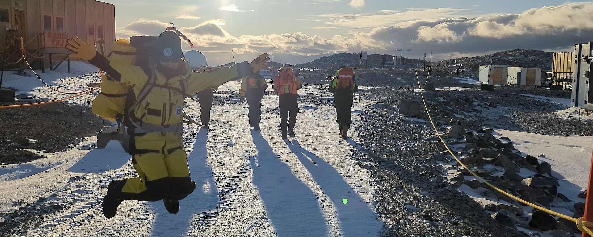 An Antarctic expeditioner jumps for joy as a group head off station to visit the local penguin colony