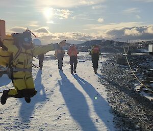 An Antarctic expeditioner jumps for joy as a group head off station to visit the local penguin colony