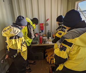 Field training officer teaching a group of expeditioners how to operate an Antarctic camping stove