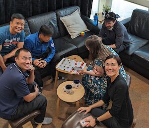 Two people playing Xiangqi (Chinese chess) while four spectators watch