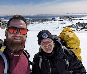 Two expeditioners taking a selfie with ice landscape in the backround