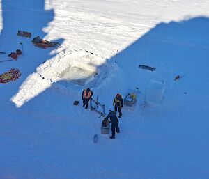 Three people are on the sea ice testing its condition and thickness