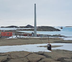 Rocky islands can be seen in the distance surrounded by frozen ocean. There are two icebergs visible to the right of frame.