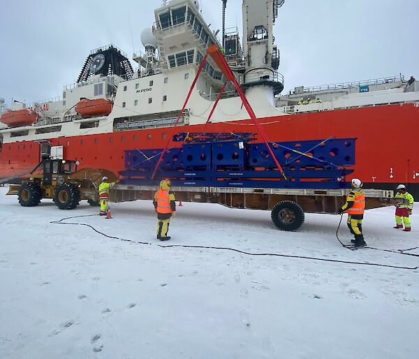 A large blue cargo box is unloaded by crane from the RSV Nuyina