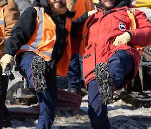 Two men showing their boot spikes