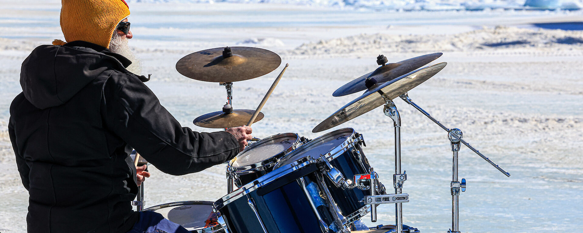 A man playing the drums on the ice