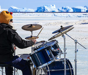 A man playing the drums on the ice