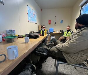 Group of expeditioners sitting in a room drinking tea