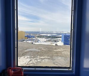 An internal portrait photo of the view from the meteorologist office window out to the station and down to the bay.