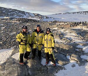 Three meteorologist forecasters Holly, Matt and Elli standing in front of a landscape filled with penguins