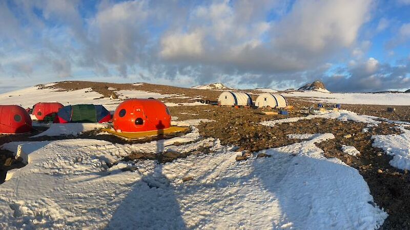 Eight red melon tents, two white mess tents and lots of snow and rock.