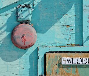 A green painted building with a sign saying Weddell on it