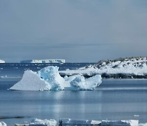 Iceberg floating on water looking like the Sydney Opera House