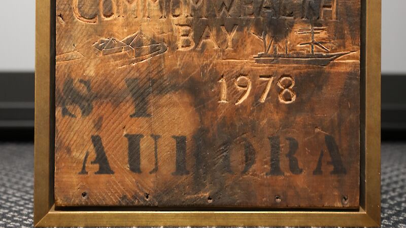 A wood box lid with Commonwealth Bay 1978 and Aurora written on it