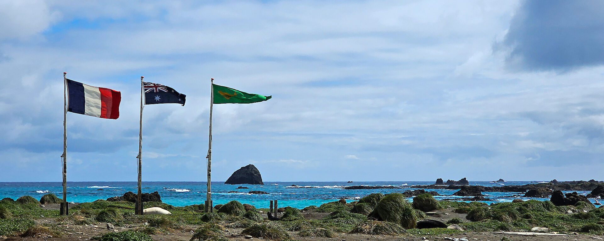 Three flags flying, the French, the Australian and the Australian National Antarctic Research Expedition (ANARE) flag.