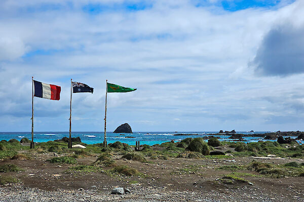 Three flags flying, the French, the Australian and the Australian National Antarctic Research Expedition (ANARE) flag.