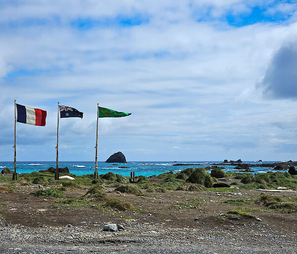 Three flags flying, the French, the Australian and the Australian National Antarctic Research Expedition (ANARE) flag.