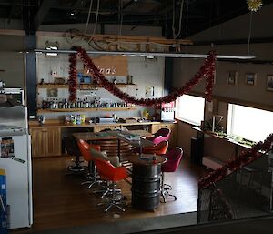 A room, known as Ninas Bar, with a fridge and Christmas decorations.