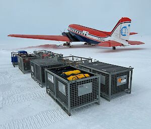 Freight containers on the snow to be loaded onto a Basler aircraft
