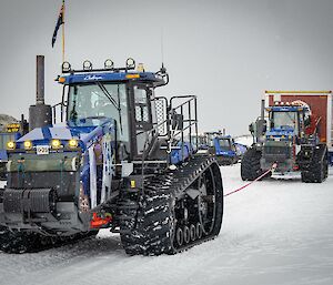 A tractor convoy driving on snow
