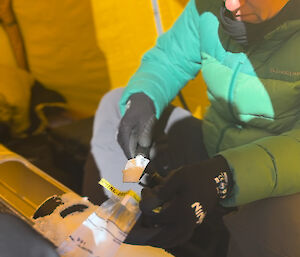 Scientist places ice chips in a bag for transfer back to the lab