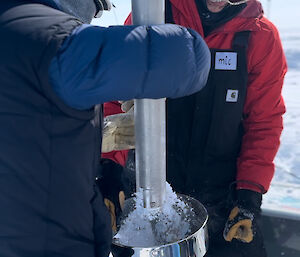 Scientists using an ice drill to collect ice chips