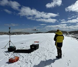 Scientist piloting a drone over Antarctic landscape