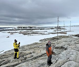 Remediation scientists standing on rocks overlooking an old station area
