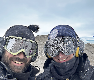 Two carpenters with mud spray over their goggles on West Arm rock.
