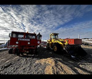 Old tracked snow machine with the old CAT loader beside it.