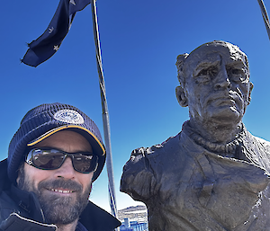 Mal standing next to the statue bust of Douglas Mawson