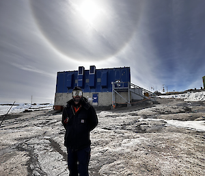 Mal standing in front of the Main Power House with an ice ring around the sun.