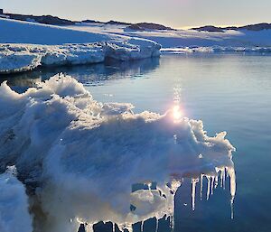 Melting ice overhangs water near the coast