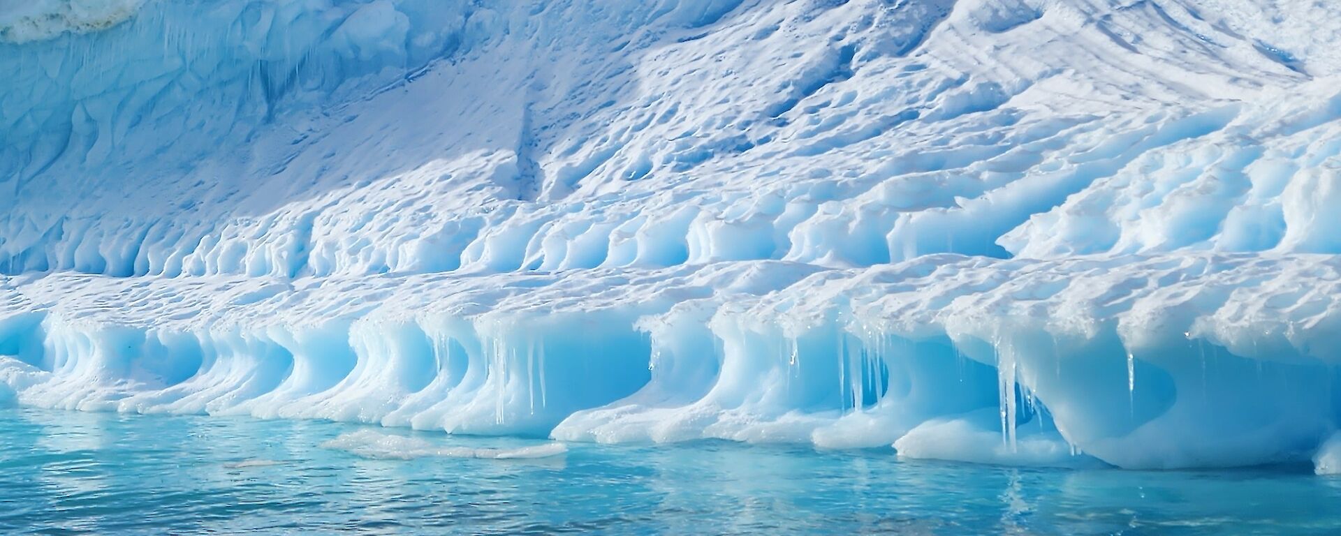 Blue ice appears to flow into the water