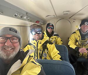Four expeditioners seated in the Twin otter flying to Mawson station.