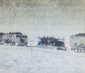Graney black and white photo of three large tracked vehicles towing sled trailers.
