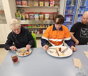 three expeditioners eating lunch. one plate very proportionality large