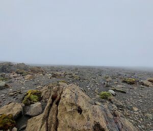 A rocky hillside with fog ahead.
