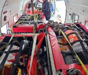 Red survival bags are packed on a plane