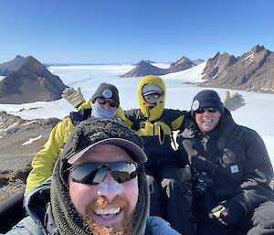 Four expos taking a selfie on top of the ridge.