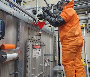 Expeditioner pouring chemicals into one of the treatment tanks at the waste water treatment plant